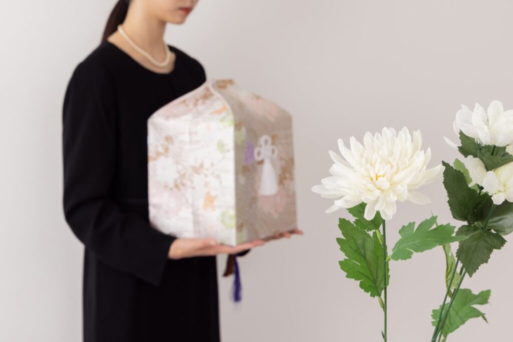 骨壺を持つ女性