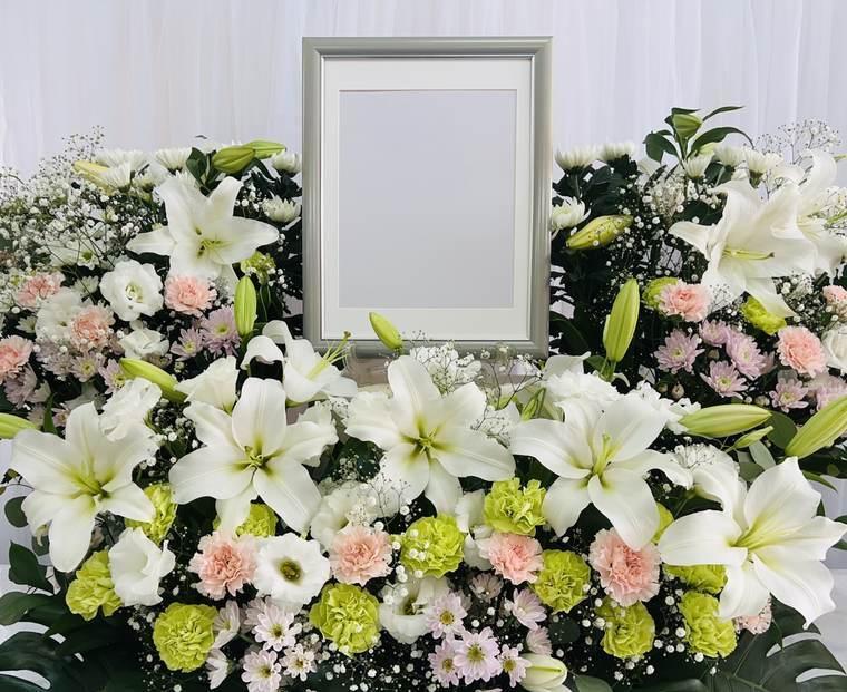 白い花と遺影額縁の祭壇