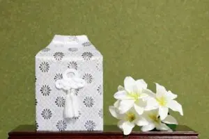 白い覆いをかけた骨壺と白百合